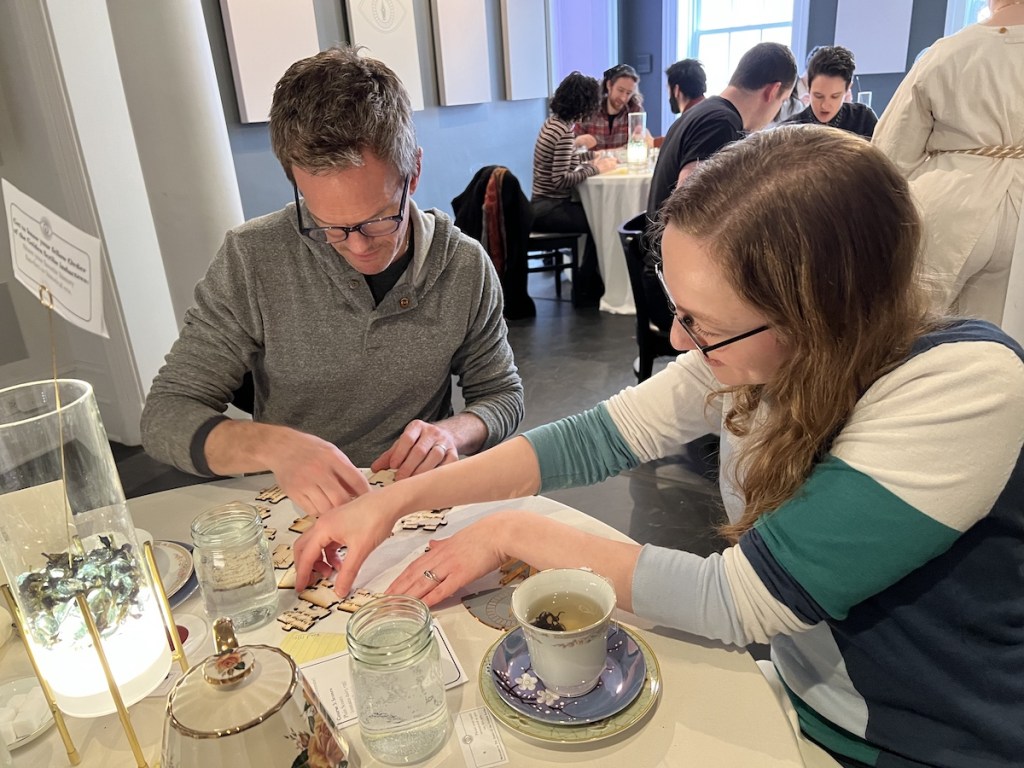 Lisa and Neil Patrick Harris solving a jigsaw puzzle during tea time.