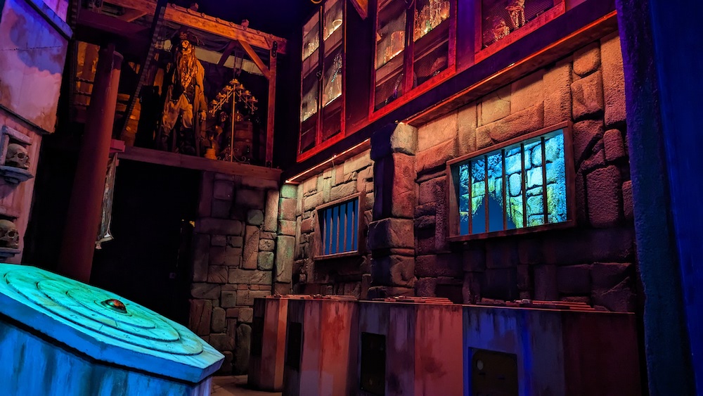 A stone a wood walled dungeon with a large stone pedestal covered in carvings.