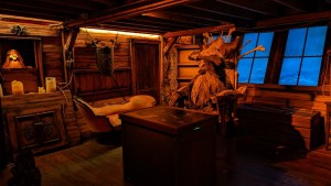 The captain's quarters on a pirate ship with a skeletal captain sitting at the desk.