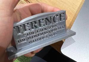 3d printed tiny gravestone, engraved with the caption "Terence, The talkapus. The world is quieter without you"