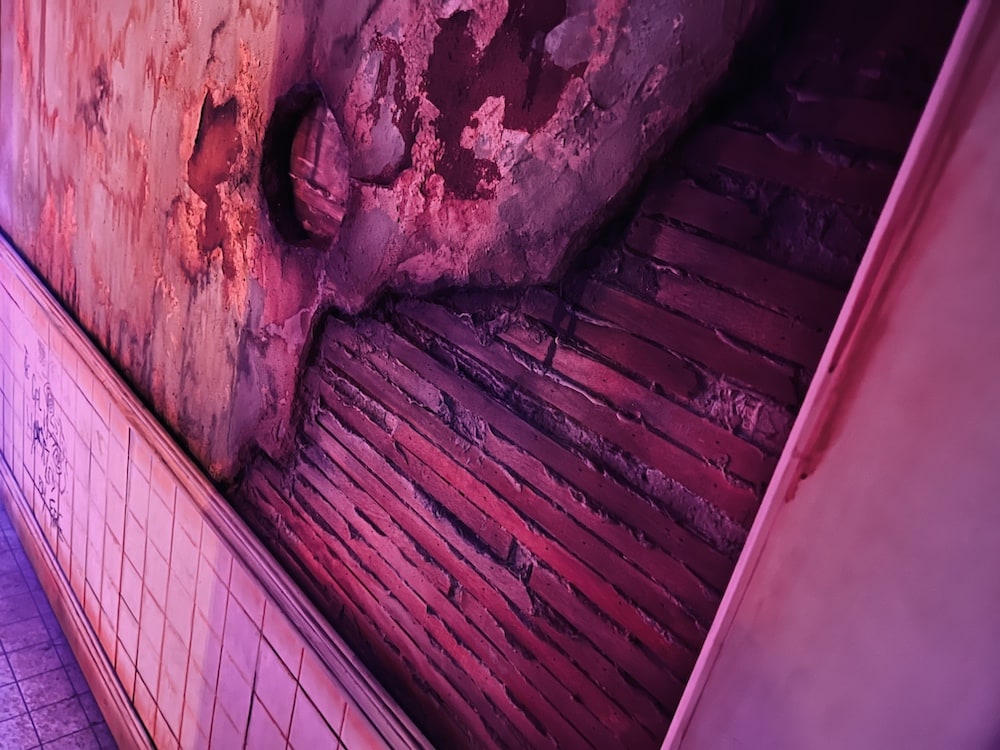 Closeup of decaying plastar walls, revealing the wooden framing behind it.