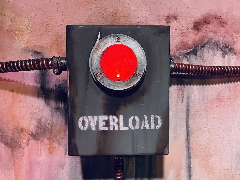 A metal box with a big red light reads, "Overload"