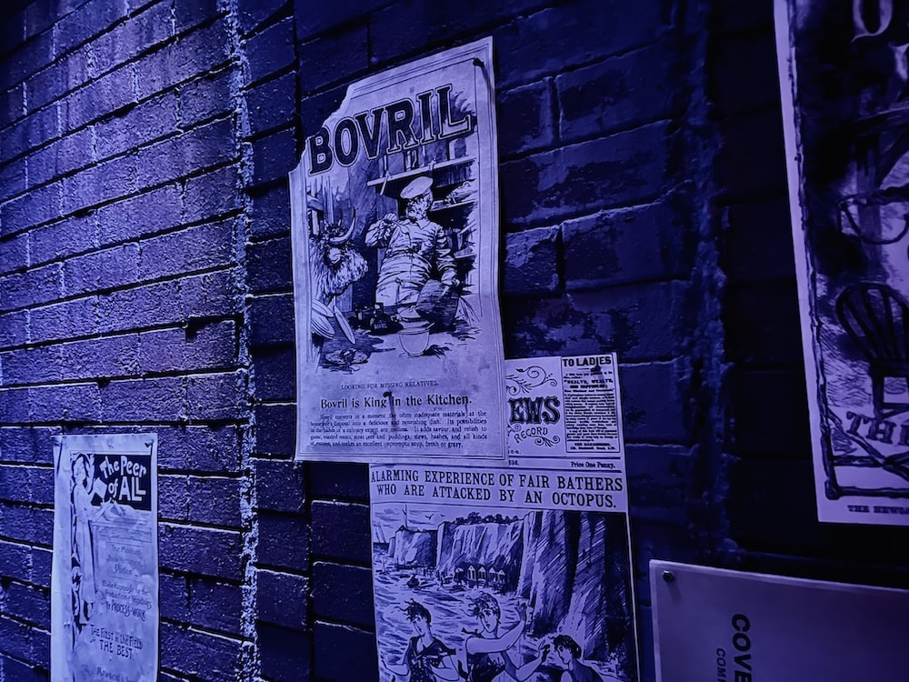Closeup of advertisements and newspaper clippings pinned to a brick wall.