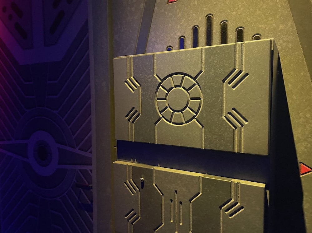 A metal wall with circular and line patterns carved into it.