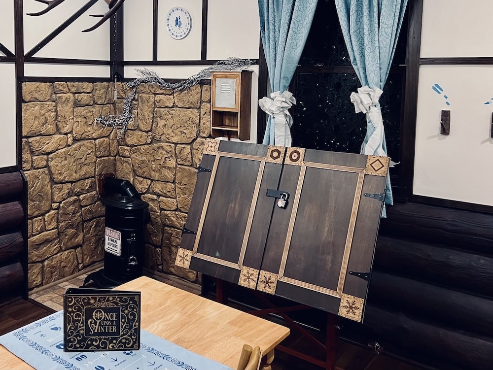 Inside of a germanic winter fairytale cabin with a book on the table, the title reads, "Once Upon a Winter"