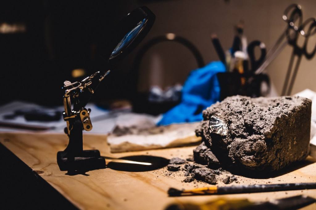 An restoration workbench with various tools and a piece of stone from a cathedral.