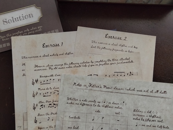 Handwritten documents labeled "Exercise 1," "Exercise 2," "Notes on Father's Music Lesson," a page with music notation, and an envelope marked "Solution"