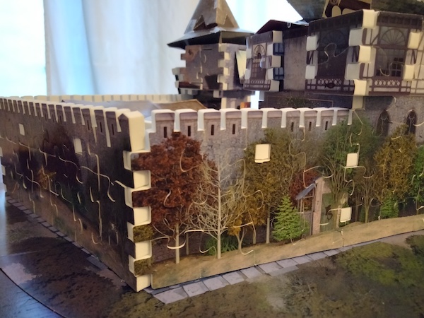 Close-up of a 3D jigsaw puzzle depicting trees lining a castle wall