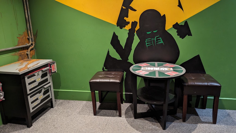 A green-walled bunker with a card table in the center.