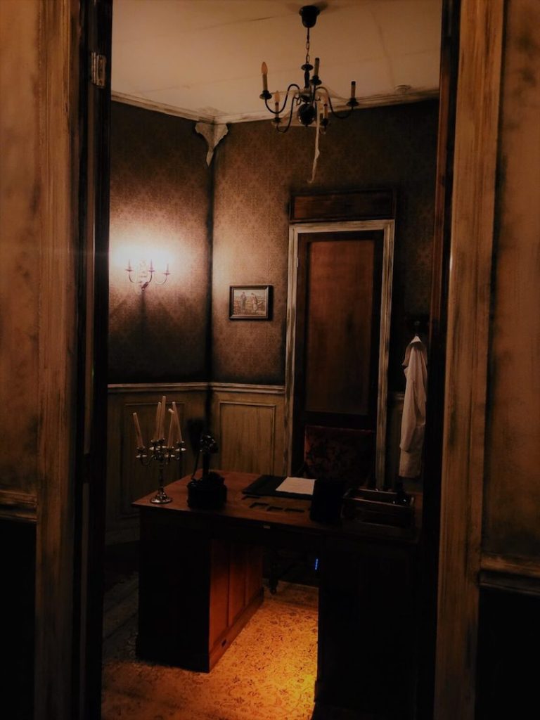 View into a study from a hallway. The home is rundown and scary.