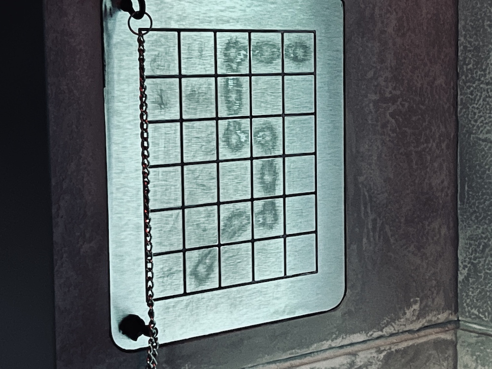 Closeup of a grid puzzle that is so heavily worn that you can easily see the solution.