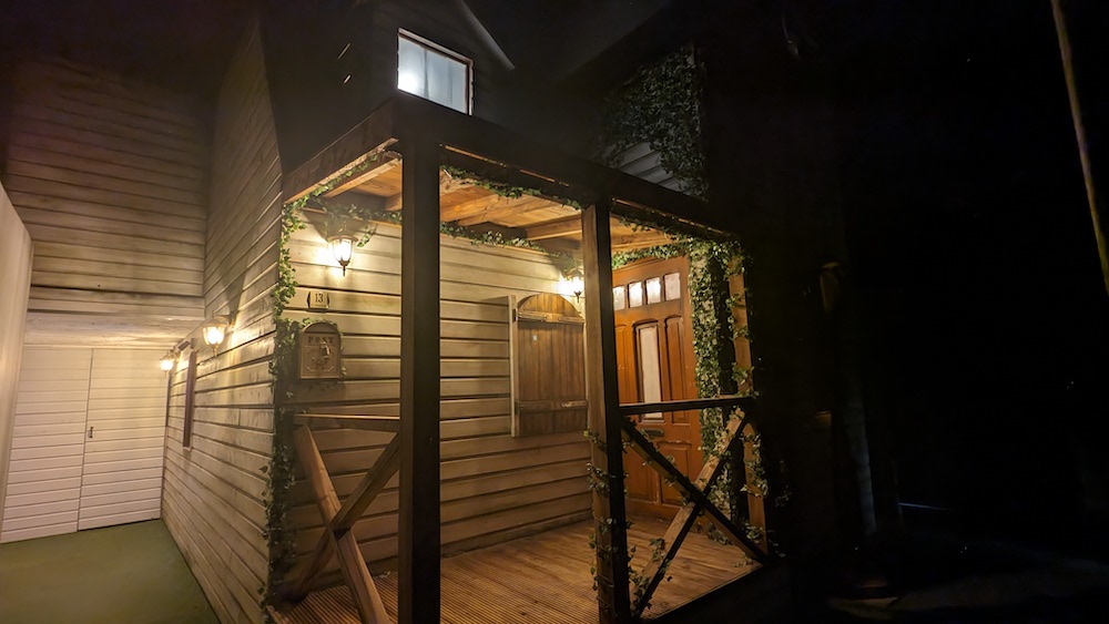 Exterior of a two floor house with ivy growing up the sides.