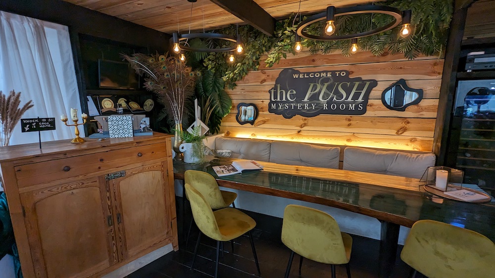 A comfortable lobby with a large sign that reads, "Welcome to The PUSH Mystery Rooms."