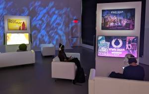A beautifully lit room with a series of couch/ screen setups where people can play game demos.