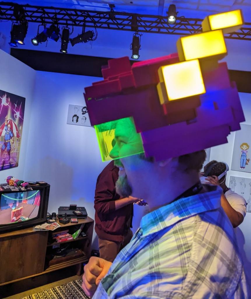 Andrew with a big grin, wearing a strange 8-bit helmet.