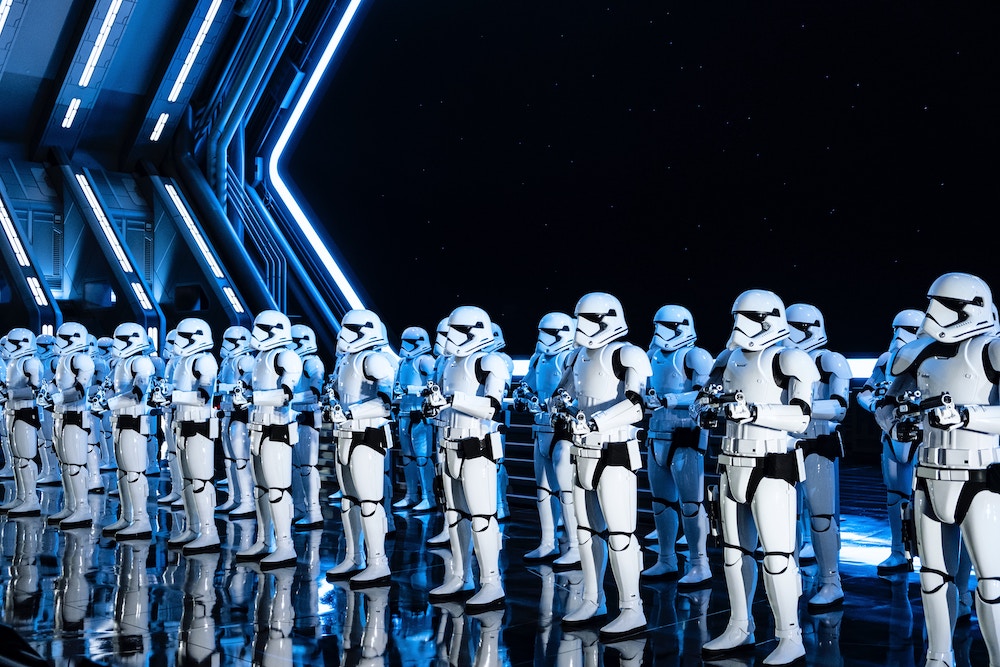 A squad of Stormtroopers standing in a ship's docking bay. The vastness of space is seen behind them.
