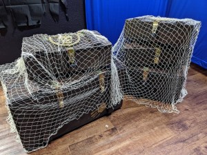 5 locked chests covered with white netting.