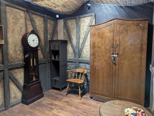 An old germanic home with a large locked wardrobe and a grandfather clock.