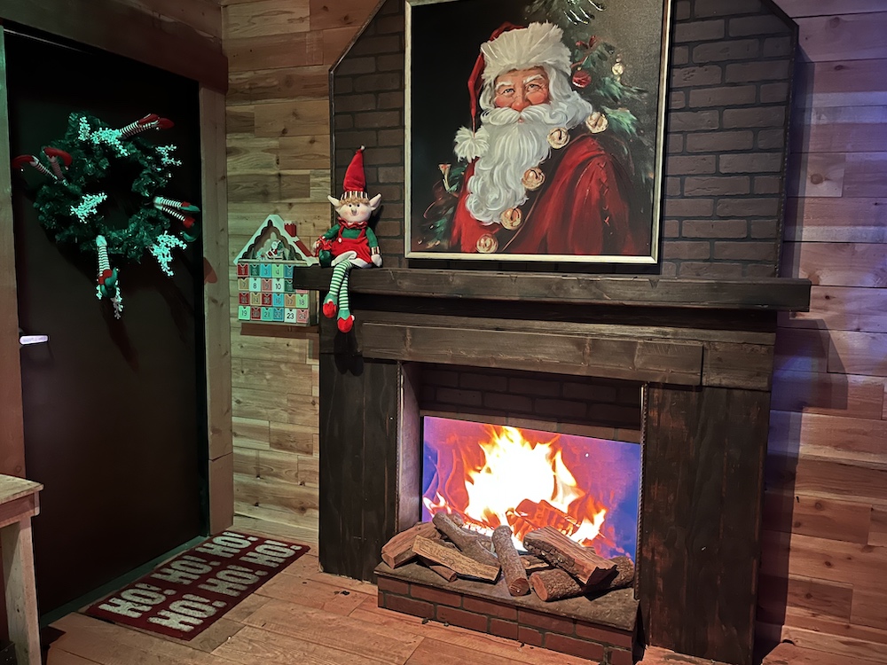 A fireplace with a portrait of Santa above it.