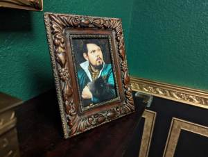 Closeup of a framed photo of a man holding a black cat.