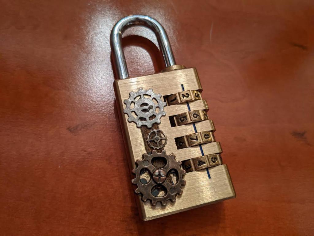Closeup of a 4 digit number lock. It is adorned with gears.