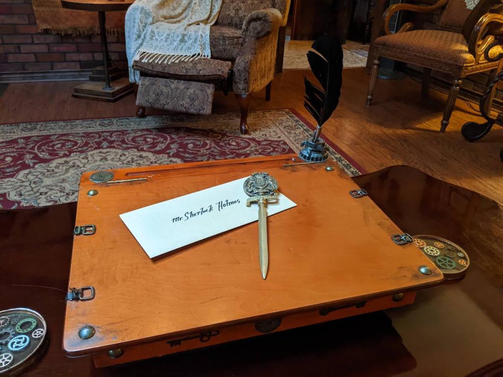 A desk with a letter to "Mr Sherlock Holmes" with a dagger-like letter opener.