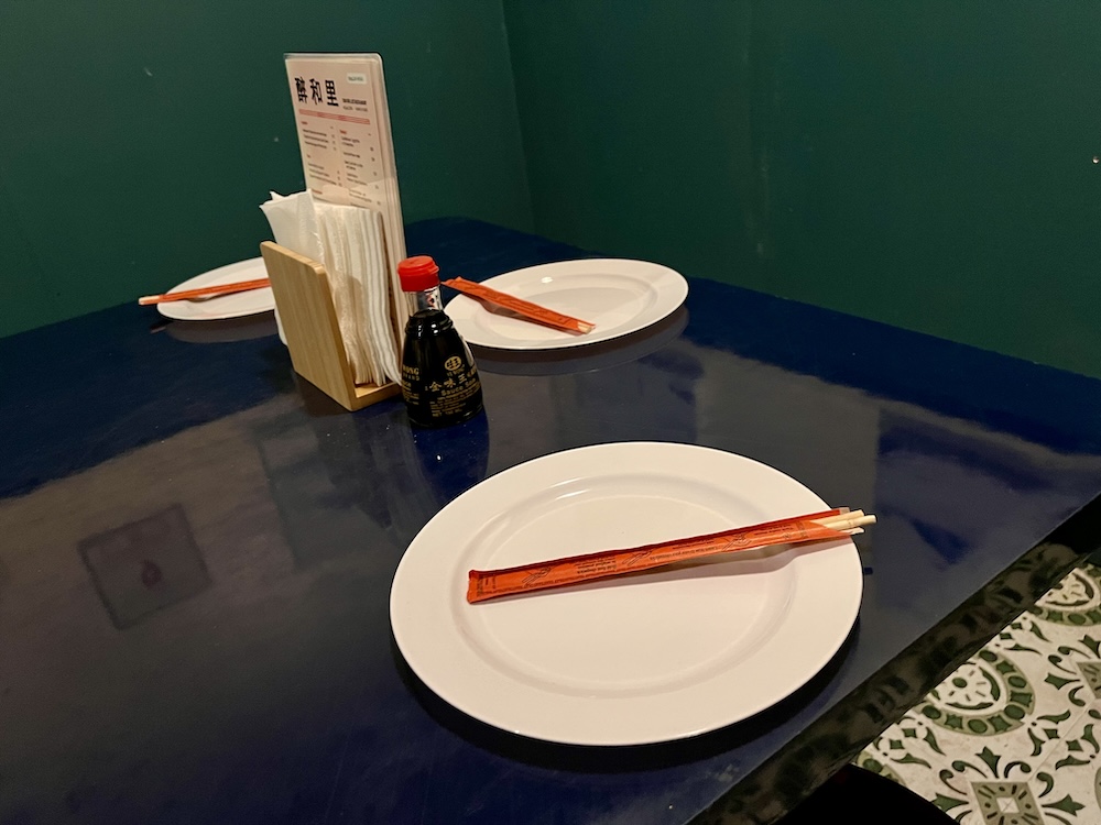 3 place settings with chopsticks in a Chinese restaurant.