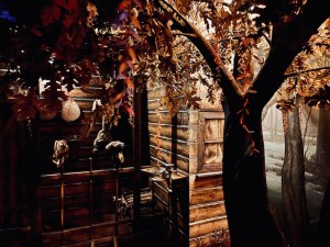 An autumn forest scene beside an ominous cabin.