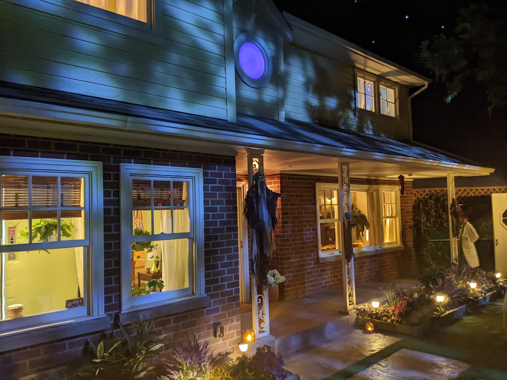 Exterior of a house at night, it is decorated for Halloween.