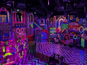 A neon covered stage with floating candles above it.