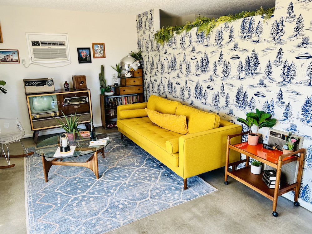 A mid century modern living room with UFO wallpaper.