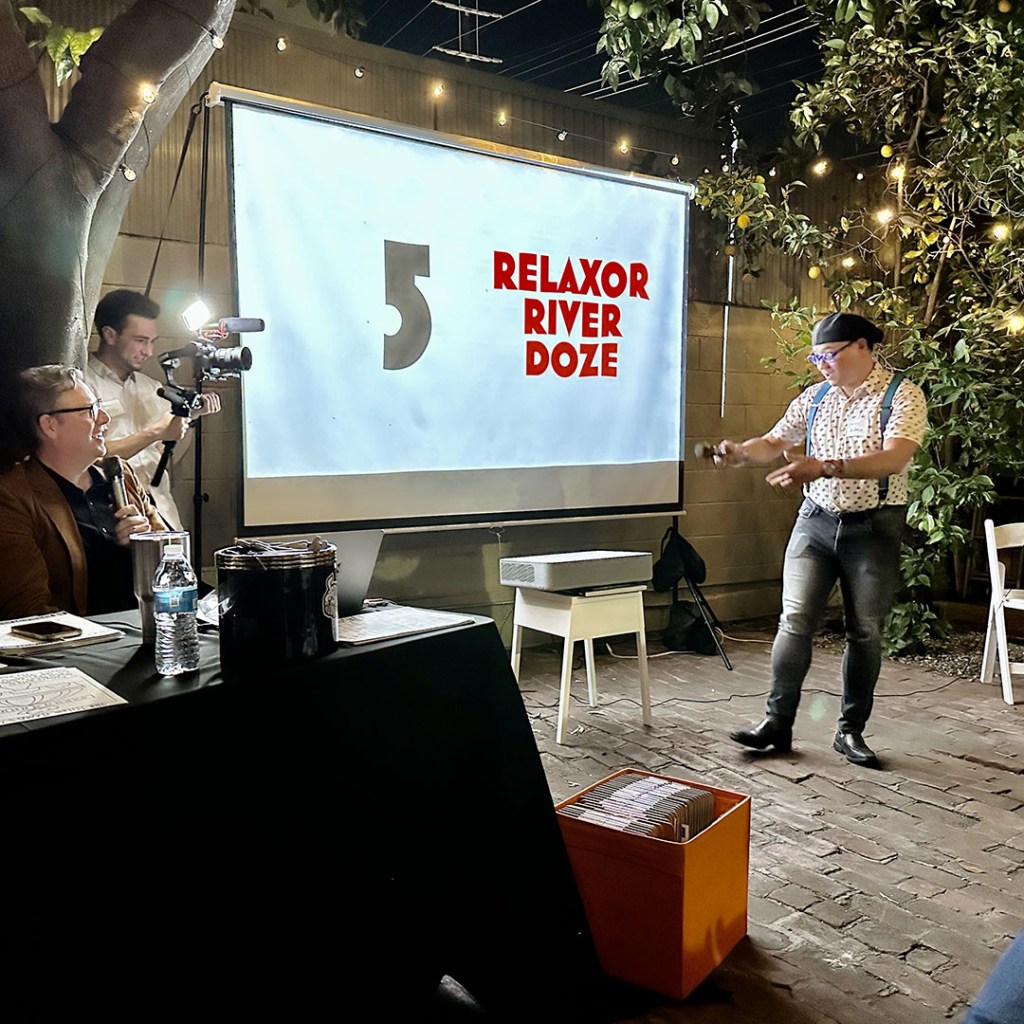 A person on stage pitching a concept while a panel of judges watch.