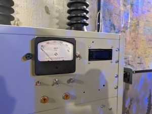A large piece of machinery with a voltage meter and an assortment of switches and lights.
