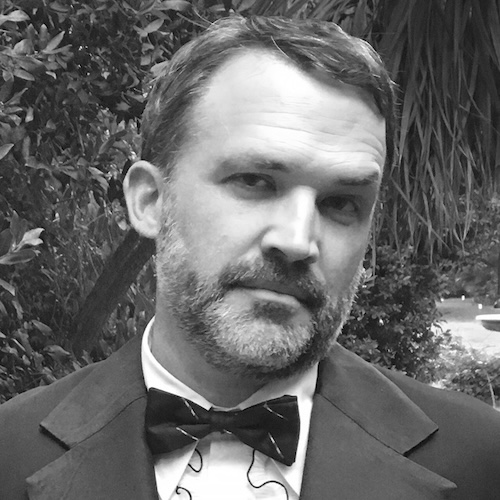 Black and white photo of Scott Olson in a suit with a bowtie.
