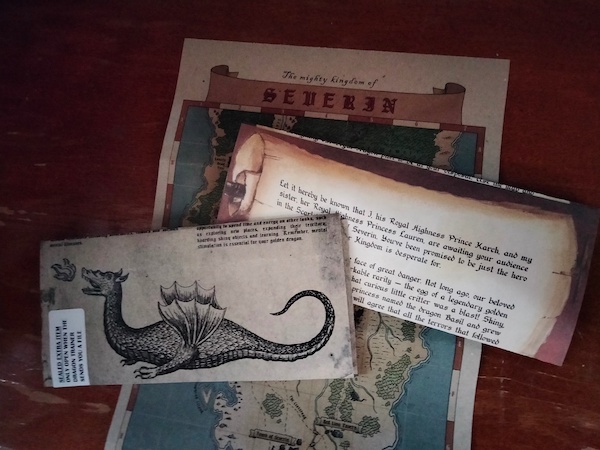 Three "weathered" documents: a map of Severin, a letter on a faux scroll, and a sealed paper with an illustration of a dragon breathing fire
