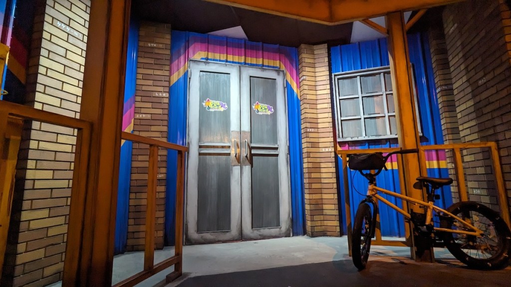 Back doors to the Click N Glitch arcade. A bicycle is locked to a post.