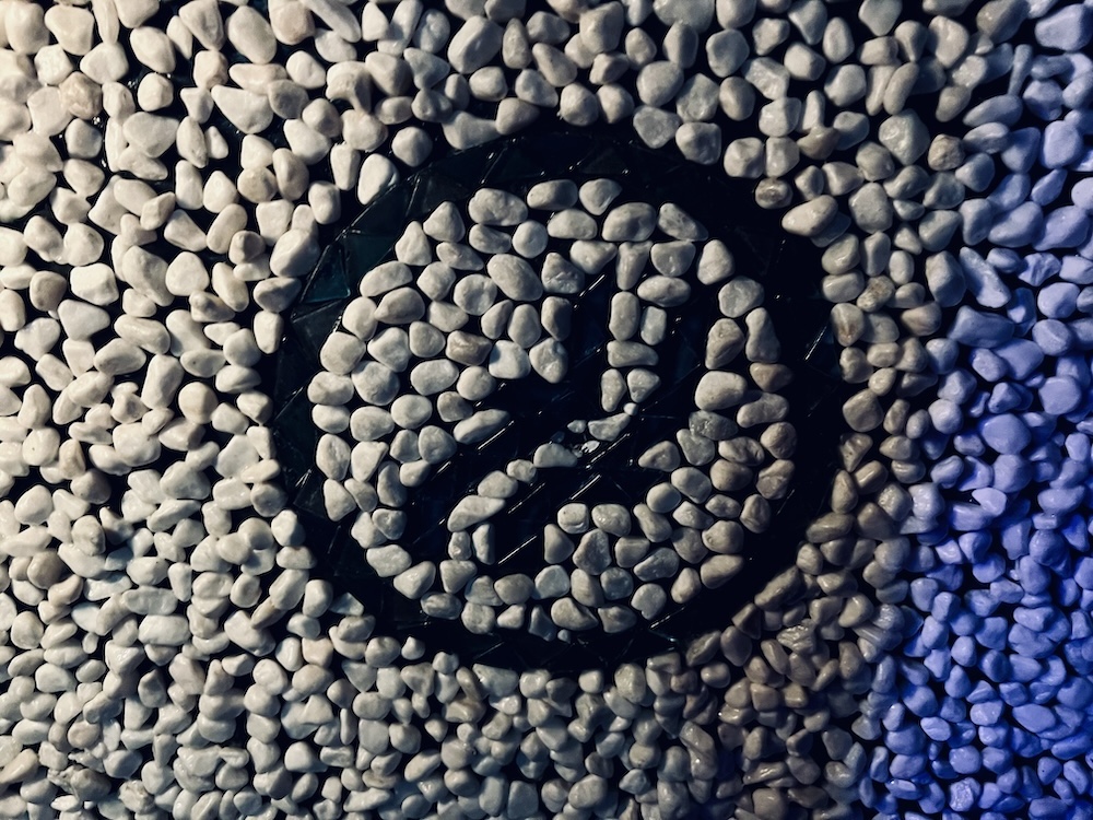 A strange black symbol set in white stones.