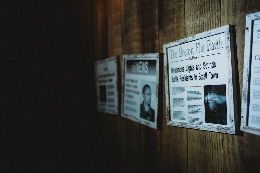 Clippings from dubious newspaper framed on a wall about mysterious happenings.