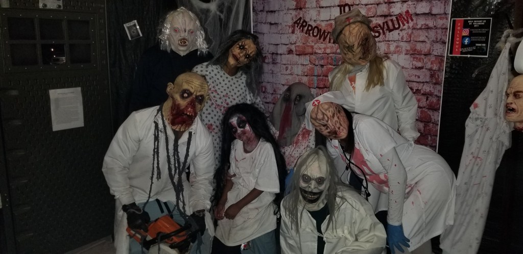 actors in scary masks posing at a home haunt