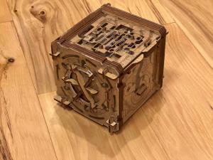 An intricate laser cut and etched wooden puzzle box.