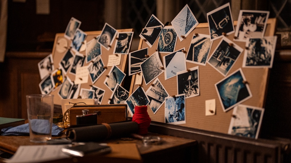 A cork-board with many photos pinned to it.