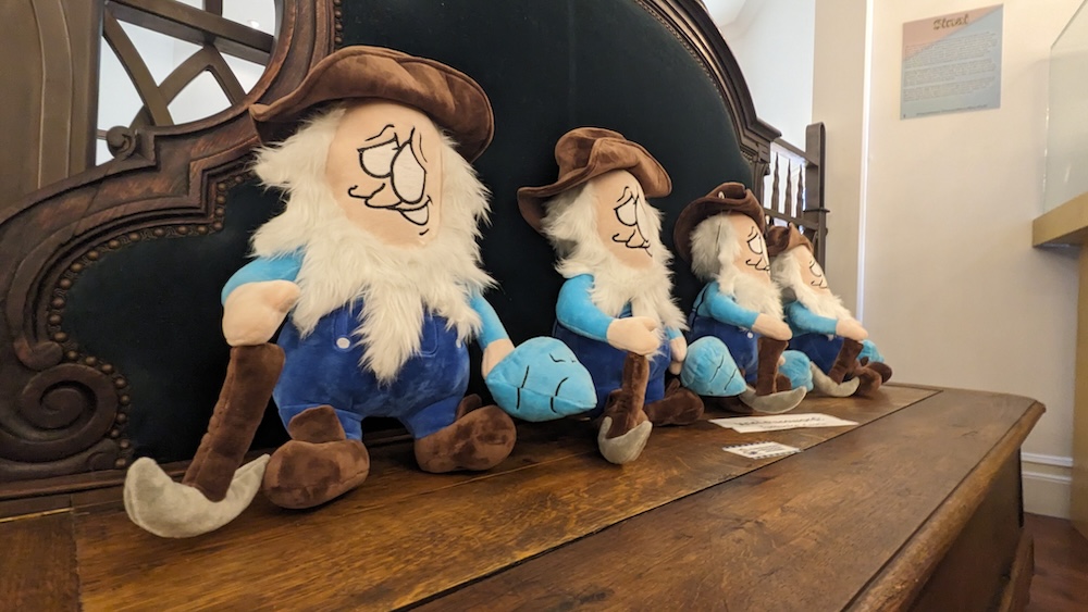 Four plushie minors with pickaxes sitting on a table.