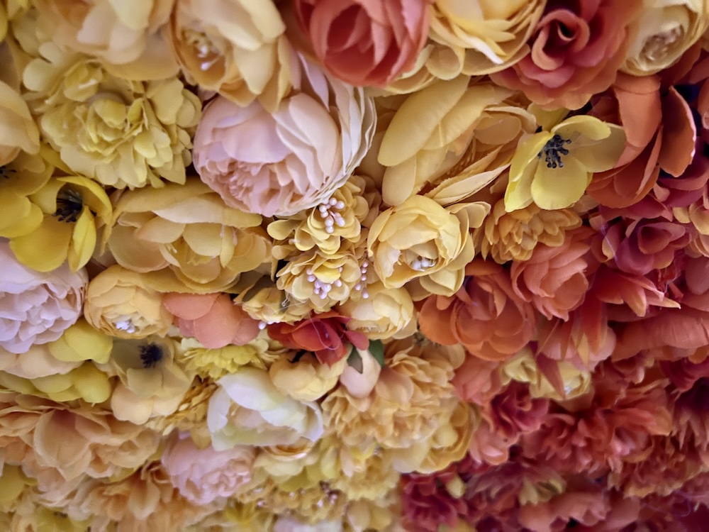 Closeup of a ceiling beautifully decorated with tightly packed silk flowers.