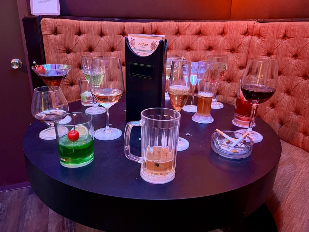 A very 70s booth with a table covered in partially consumed drinks.