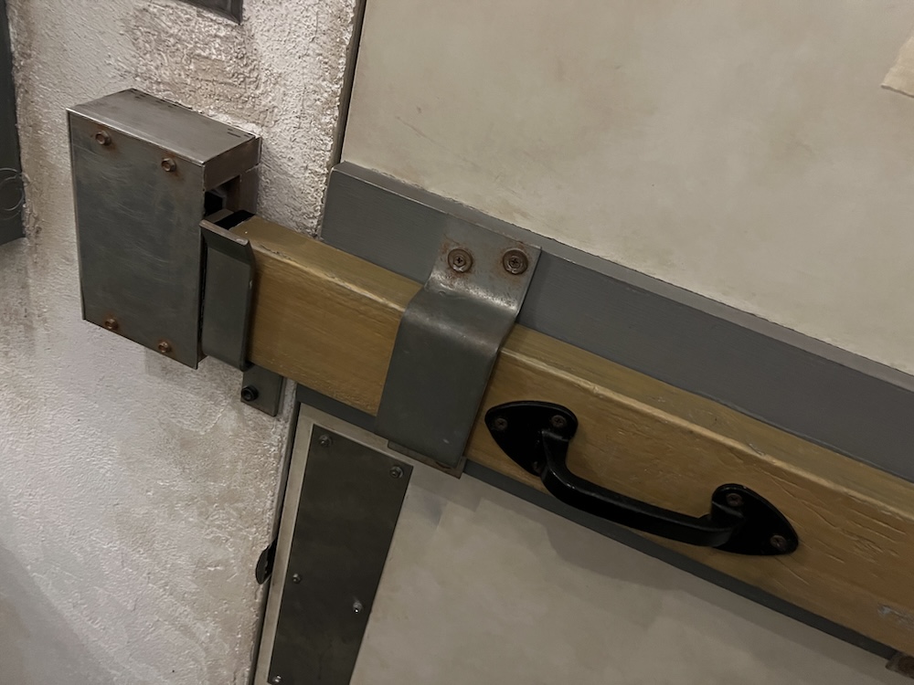 A wooden board mounted to a doo, holding it closed.