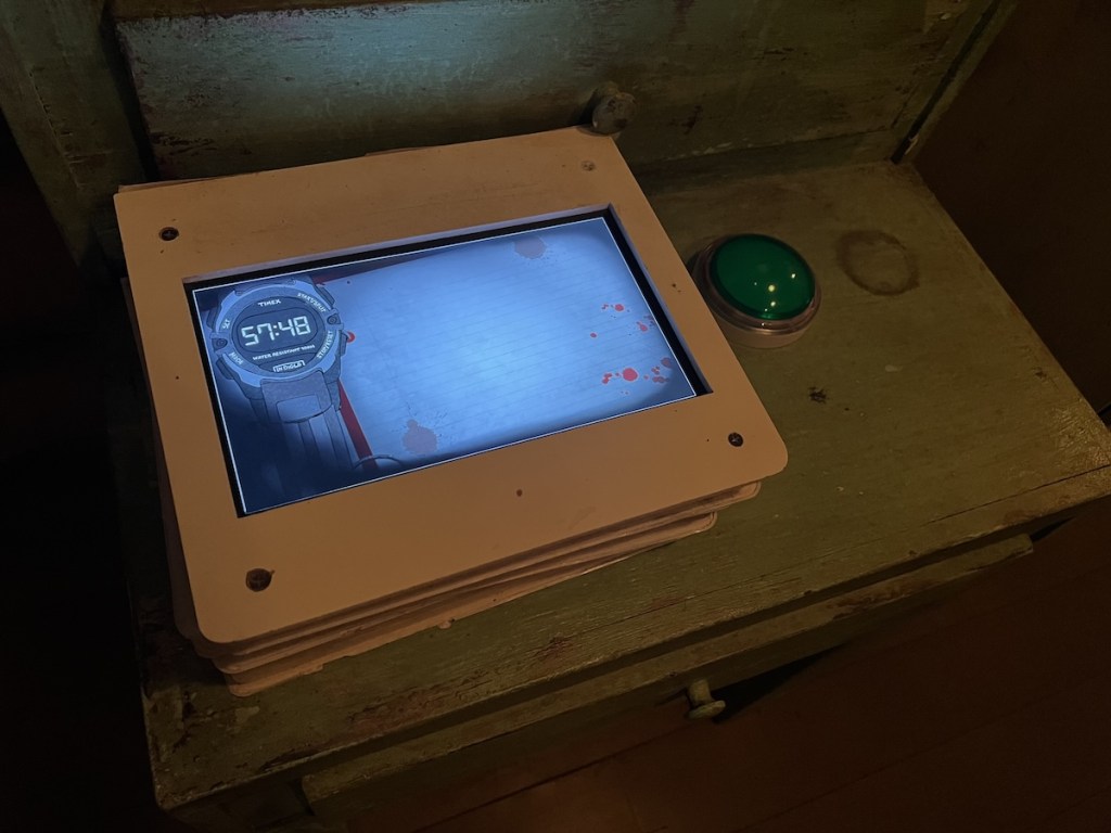 A touch screen mounted to a desk with a game clock.