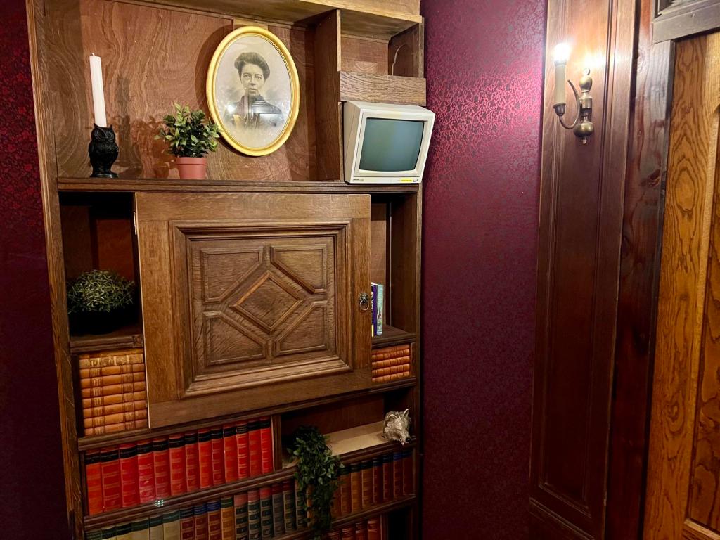 A bookcase filled with books, and strangely, an old CRT monitor.