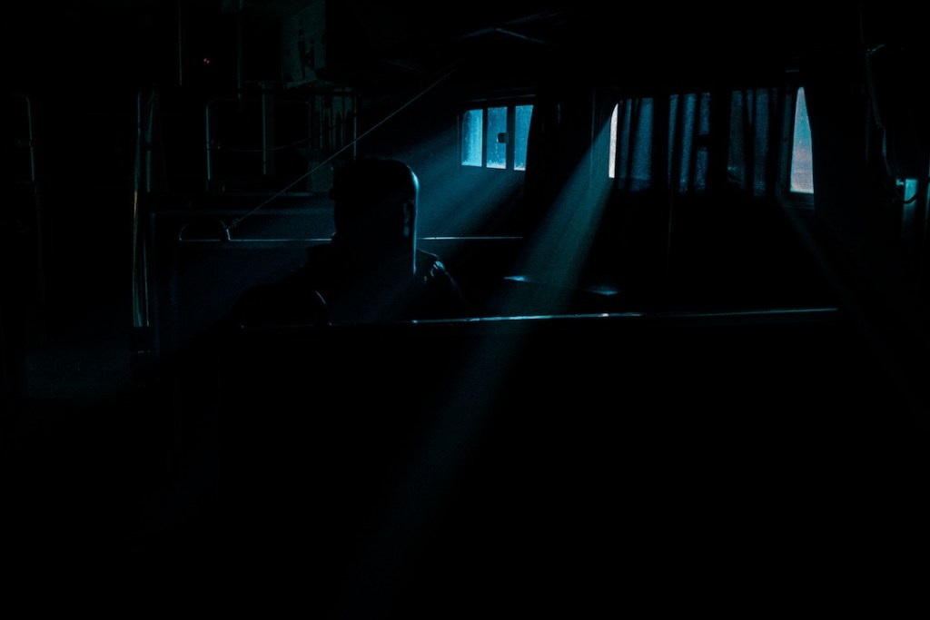 The interior of a train car at night, with a small amount of light shining in through the windows.