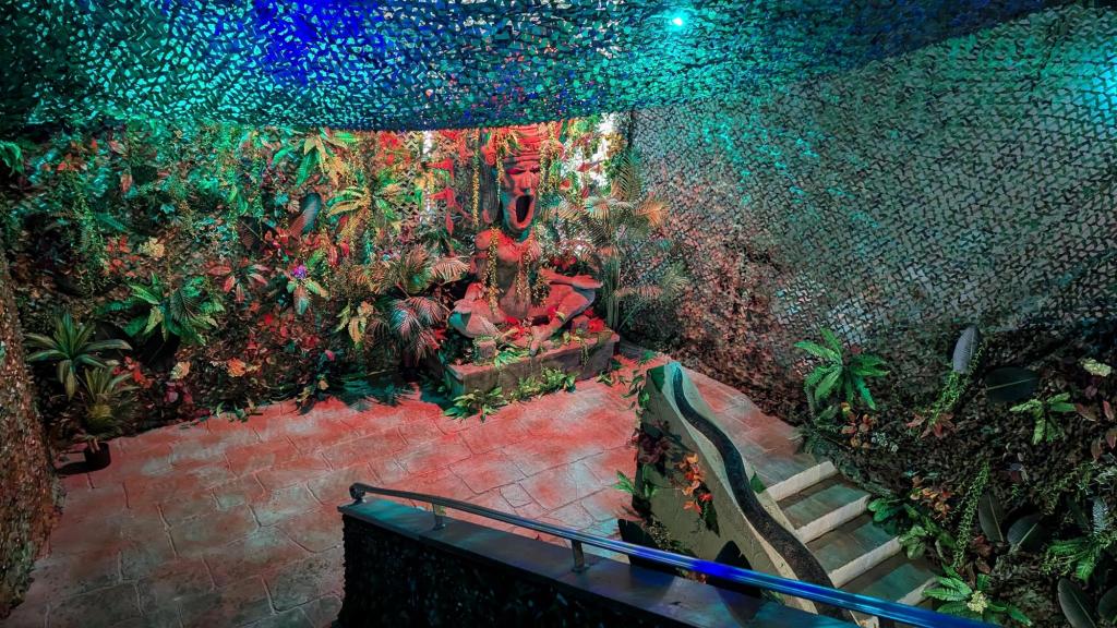 A large stairwell, decorated like a jungle with a large statue.