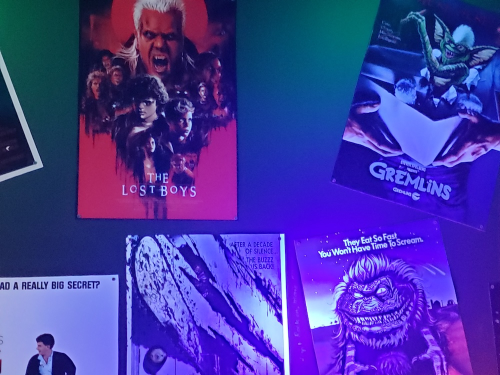 Posters hung on the wall from The Lost Boys, Gremlins, and more.